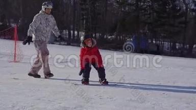 年轻人<strong>滑雪板</strong>教练教小男孩如何骑<strong>滑雪板</strong>。 冬季活动概念